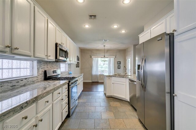 2111 Tiger Links Dr, Henderson, NV 89012 - kitchen with stainless steel appliances, recessed lighting, a sink, white cabinetry, and baseboards