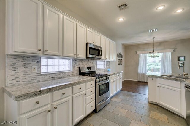 2111 Tiger Links Dr, Henderson, NV 89012 - kitchen with appliances with stainless steel finishes, a sink, decorative backsplash, baseboards, and white cabinetry
