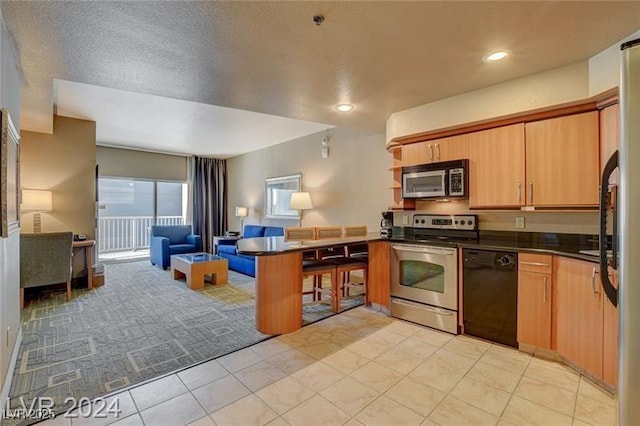 211 E Flamingo Rd Unit 615, Las Vegas, NV 89169 - kitchen with appliances with stainless steel finishes, dark countertops, open floor plan, a peninsula, and light tile patterned flooring