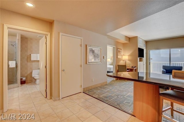211 E Flamingo Rd Unit 615, Las Vegas, NV 89169 - kitchen with a breakfast bar area, light tile patterned flooring, recessed lighting, and a desk