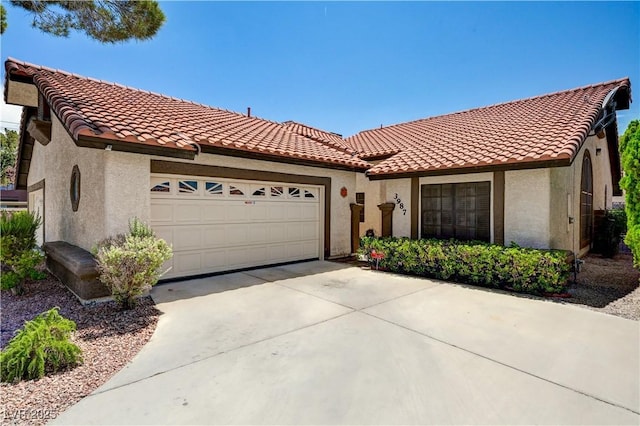 3987 Saddlewood Ct, Las Vegas, NV 89121 - mediterranean / spanish house featuring a tiled roof, a garage, stucco siding, and concrete driveway