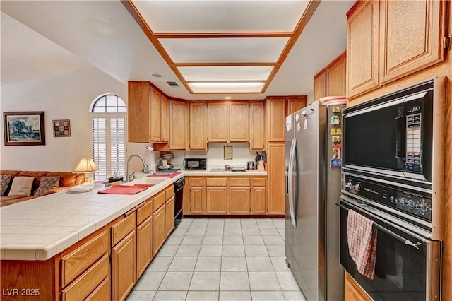 3987 Saddlewood Ct, Las Vegas, NV 89121 - kitchen featuring black appliances, a peninsula, light tile patterned flooring, open floor plan, and a sink