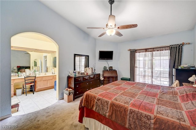 3987 Saddlewood Ct, Las Vegas, NV 89121 - bedroom featuring light colored carpet, vaulted ceiling, arched walkways, ensuite bathroom, and light tile patterned flooring