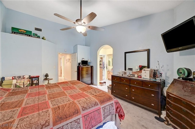 3987 Saddlewood Ct, Las Vegas, NV 89121 - bedroom with arched walkways, light carpet, ensuite bath, and a ceiling fan