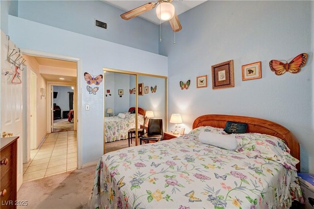 3987 Saddlewood Ct, Las Vegas, NV 89121 - bedroom featuring a closet, light carpet, a high ceiling, ceiling fan, and light tile patterned floors