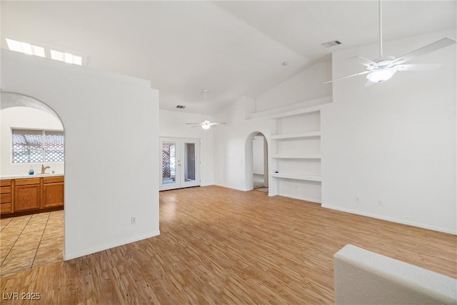 3580 S Shawnee Ave, Pahrump, NV 89048 - unfurnished living room with built in features, ceiling fan, light wood-type flooring, high vaulted ceiling, and a sink