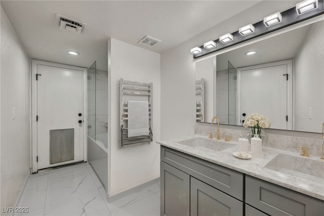 3421 Rochelle Ct, Las Vegas, NV 89121 - full bathroom featuring a towel warmer, marble look tiles, double vanity, radiator heating unit, and recessed lighting