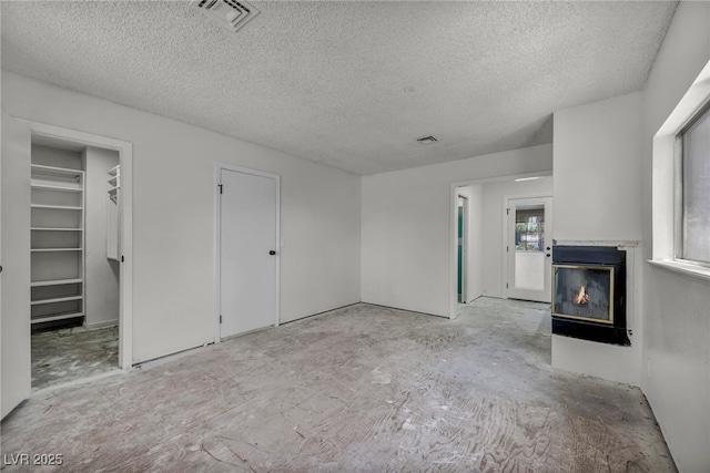 3421 Rochelle Ct, Las Vegas, NV 89121 - unfurnished living room featuring a textured ceiling and a glass covered fireplace