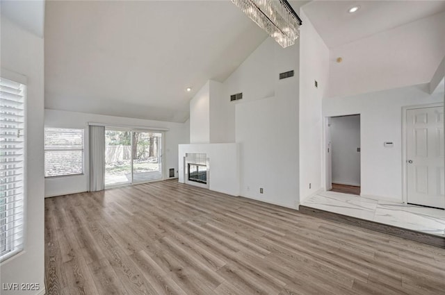 6944 Emerald Springs Ln, Las Vegas, NV 89113 - unfurnished living room featuring high vaulted ceiling, wood finished floors, a multi sided fireplace, and recessed lighting