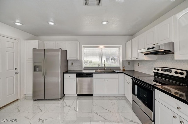 6944 Emerald Springs Ln, Las Vegas, NV 89113 - kitchen featuring stainless steel appliances, under cabinet range hood, dark countertops, white cabinetry, and recessed lighting
