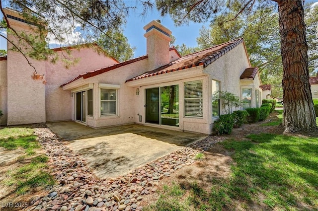 6944 Emerald Springs Ln, Las Vegas, NV 89113 - back of property featuring a chimney, a tile roof, stucco siding, and a patio