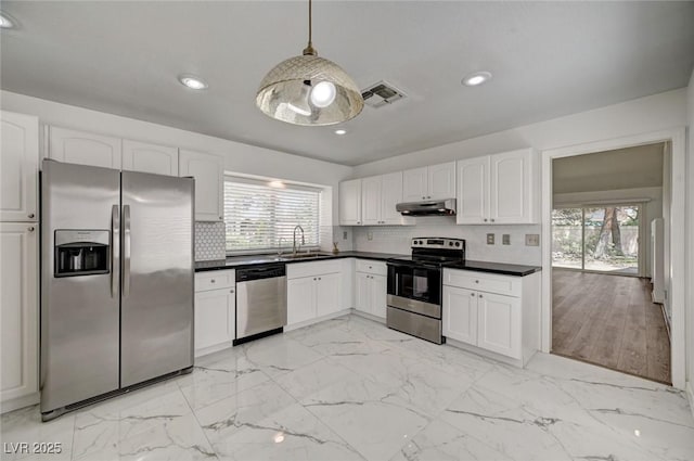 6944 Emerald Springs Ln, Las Vegas, NV 89113 - kitchen featuring appliances with stainless steel finishes, under cabinet range hood, dark countertops, healthy amount of natural light, and recessed lighting