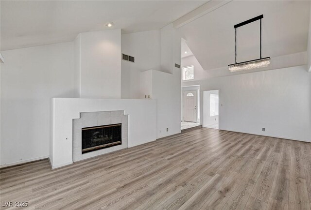6944 Emerald Springs Ln, Las Vegas, NV 89113 - unfurnished living room featuring high vaulted ceiling, wood finished floors, beamed ceiling, and a tile fireplace
