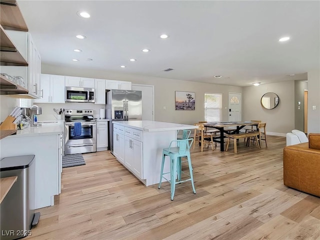 4072 E Harmon Ave, Las Vegas, NV 89121 - kitchen featuring appliances with stainless steel finishes, light countertops, recessed lighting, white cabinets, and light wood finished floors