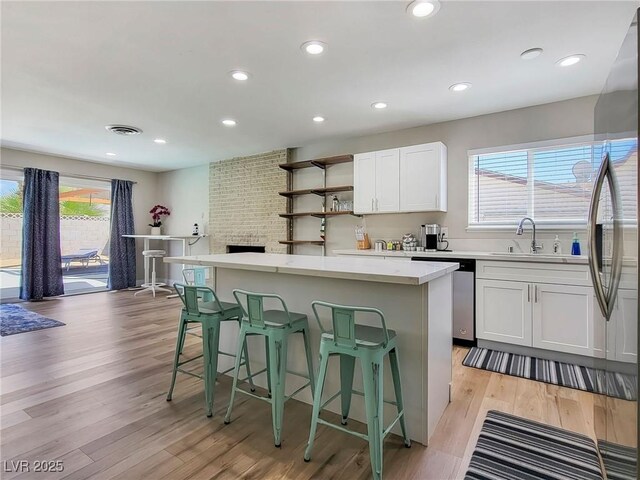 4072 E Harmon Ave, Las Vegas, NV 89121 - kitchen with dishwasher, a sink, a kitchen island, a breakfast bar area, and recessed lighting