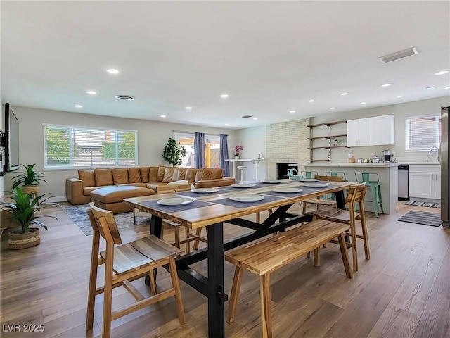 4072 E Harmon Ave, Las Vegas, NV 89121 - dining room with light wood-type flooring, recessed lighting, and a brick fireplace