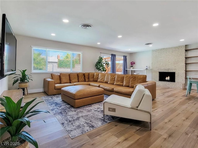 4072 E Harmon Ave, Las Vegas, NV 89121 - living room featuring light wood-style floors, recessed lighting, a brick fireplace, and baseboards