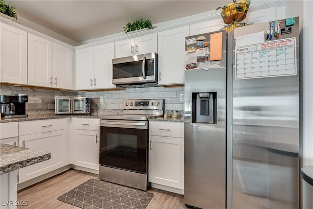 12110 Midnight Pine Rd Unit 4, Las Vegas, NV 89183 - kitchen featuring stainless steel appliances, light wood-style floors, stone counters, and white cabinetry