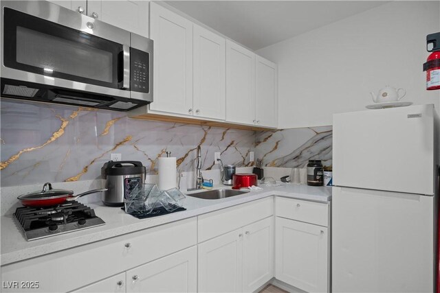 5375 Chestnut St, Las Vegas, NV 89119 - kitchen with stainless steel appliances, light countertops, white cabinets, and decorative backsplash