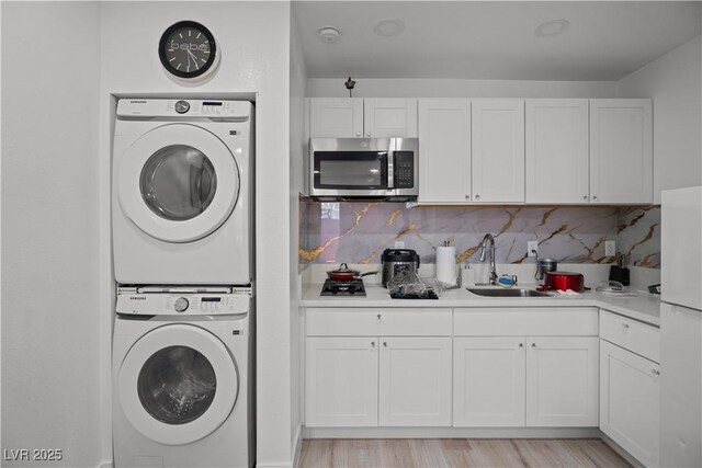 5375 Chestnut St, Las Vegas, NV 89119 - laundry area with stacked washing machine and dryer and light wood finished floors