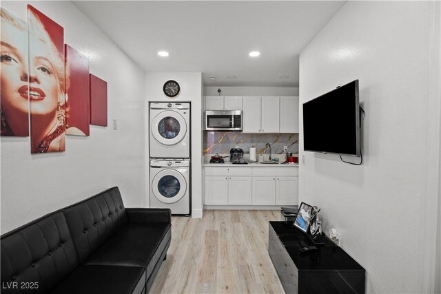 5375 Chestnut St, Las Vegas, NV 89119 - laundry room with stacked washing machine and dryer, light wood-style floors, and recessed lighting