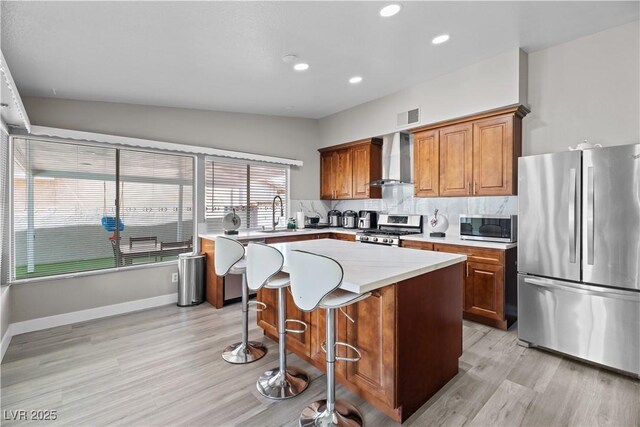 5375 Chestnut St, Las Vegas, NV 89119 - kitchen with stainless steel appliances, wall chimney exhaust hood, light wood-type flooring, decorative backsplash, and light countertops