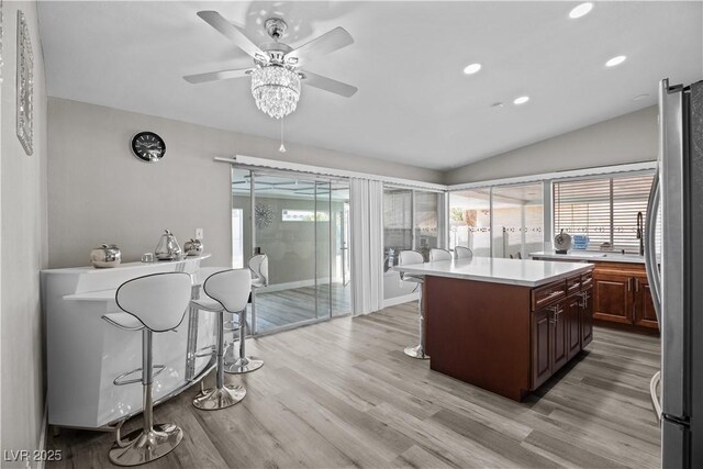 5375 Chestnut St, Las Vegas, NV 89119 - kitchen with freestanding refrigerator, a ceiling fan, light countertops, light wood-type flooring, and a center island