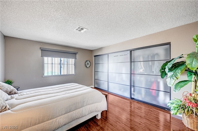 7952 Diamond Rock Way Unit 102, Las Vegas, NV 89128 - bedroom with a textured ceiling and wood finished floors