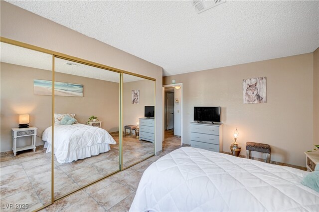 7952 Diamond Rock Way Unit 102, Las Vegas, NV 89128 - tiled bedroom with a closet and a textured ceiling