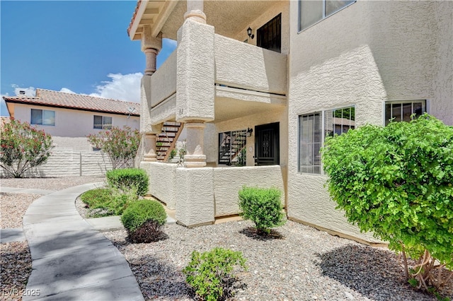 7952 Diamond Rock Way Unit 102, Las Vegas, NV 89128 - view of side of home featuring stucco siding and stairway