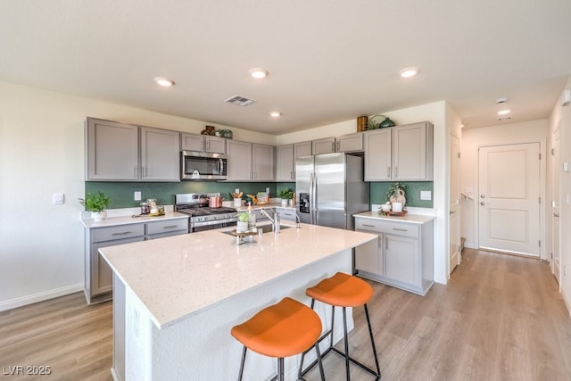 1421 Gable Falls Pl Unit 92, North Las Vegas, NV 89084 - kitchen featuring stainless steel appliances, gray cabinets, light wood finished floors, a breakfast bar area, and recessed lighting