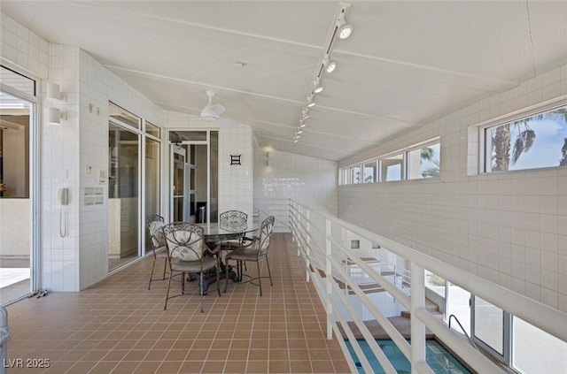 2925 Coast Line Ct, Las Vegas, NV 89117 - dining area with rail lighting, tile walls, and tile patterned flooring
