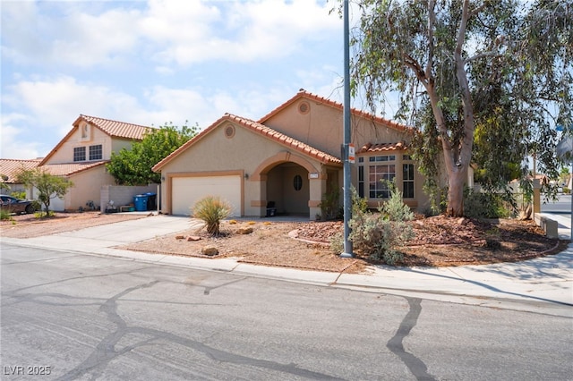 4335 Twin Peaks Dr, North Las Vegas, NV 89032 - mediterranean / spanish house with concrete driveway, a tiled roof, a garage, and stucco siding