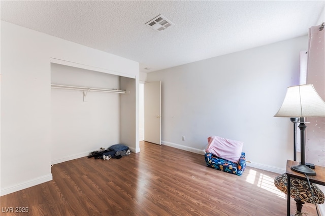 4335 Twin Peaks Dr, North Las Vegas, NV 89032 - unfurnished bedroom featuring wood finished floors, a textured ceiling, and a closet