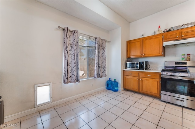 4335 Twin Peaks Dr, North Las Vegas, NV 89032 - kitchen with appliances with stainless steel finishes, under cabinet range hood, brown cabinetry, and light countertops