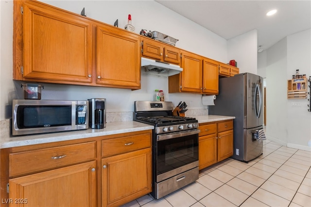 4335 Twin Peaks Dr, North Las Vegas, NV 89032 - kitchen featuring stainless steel appliances, under cabinet range hood, light countertops, brown cabinets, and recessed lighting