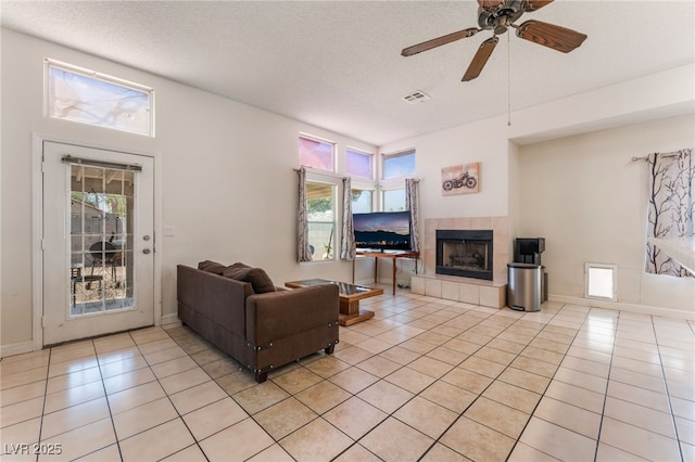 4335 Twin Peaks Dr, North Las Vegas, NV 89032 - living room with a fireplace, light tile patterned flooring, ceiling fan, and a textured ceiling