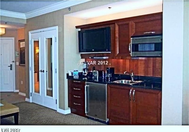 125 E Harmon Ave Unit 1918, Las Vegas, NV 89109 - kitchen featuring stainless steel microwave, a sink, ornamental molding, dark countertops, and dark carpet