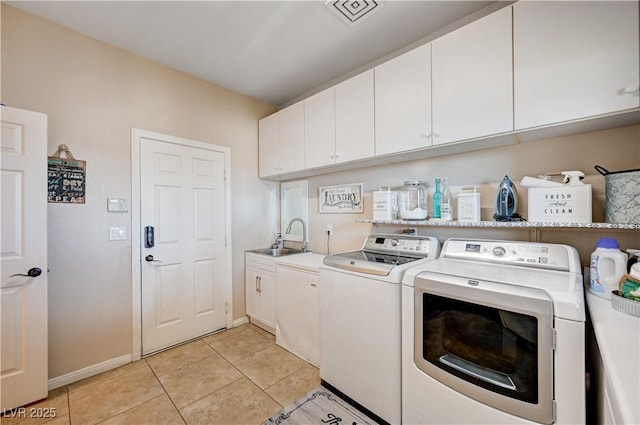 6821 Jeanette St, Las Vegas, NV 89131 - laundry room with washer and clothes dryer, light tile patterned floors, cabinet space, and baseboards