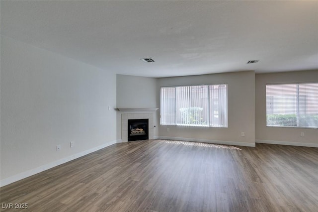 350 S Durango Dr Unit 103, Las Vegas, NV 89145 - unfurnished living room with wood finished floors, a tiled fireplace, and baseboards