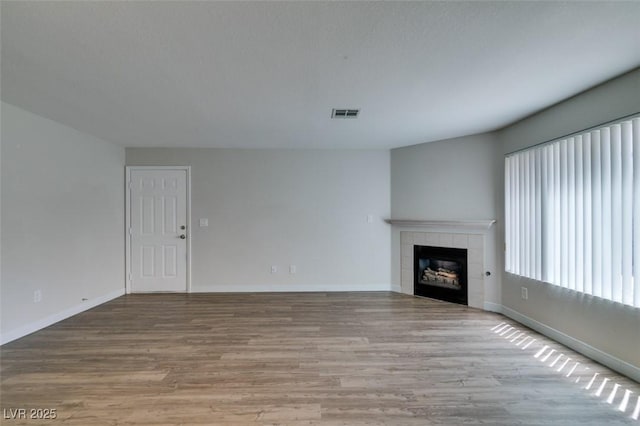 350 S Durango Dr Unit 103, Las Vegas, NV 89145 - unfurnished living room featuring wood finished floors, a fireplace, and baseboards