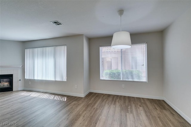 350 S Durango Dr Unit 103, Las Vegas, NV 89145 - unfurnished living room featuring wood finished floors, baseboards, and a fireplace