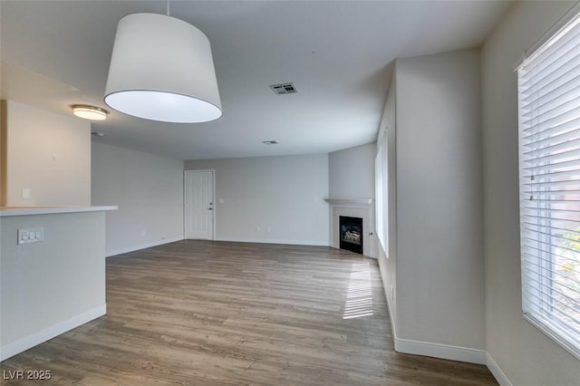 350 S Durango Dr Unit 103, Las Vegas, NV 89145 - unfurnished living room with wood finished floors, baseboards, and a fireplace