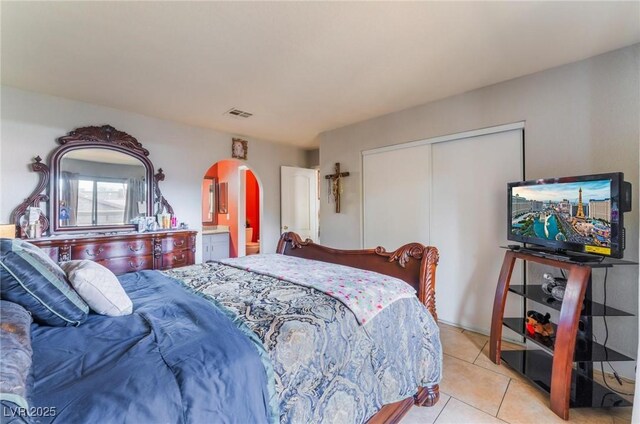 1812 N Decatur Blvd Unit 103, Las Vegas, NV 89108 - bedroom with arched walkways, a closet, and light tile patterned floors