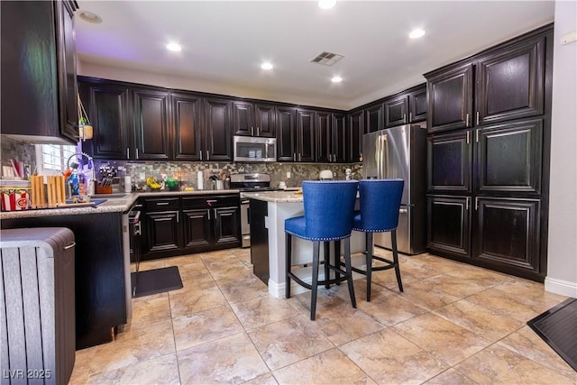 10526 Harvest Wind Dr, Las Vegas, NV 89135 - kitchen featuring stainless steel appliances, backsplash, a kitchen breakfast bar, a center island, and recessed lighting