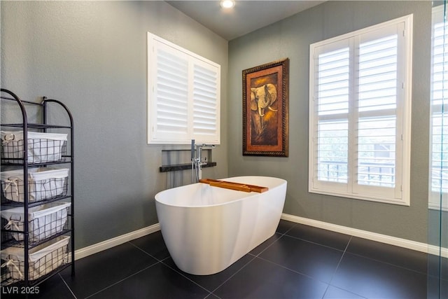 10526 Harvest Wind Dr, Las Vegas, NV 89135 - bathroom with a freestanding bath, tile patterned flooring, baseboards, and a textured wall