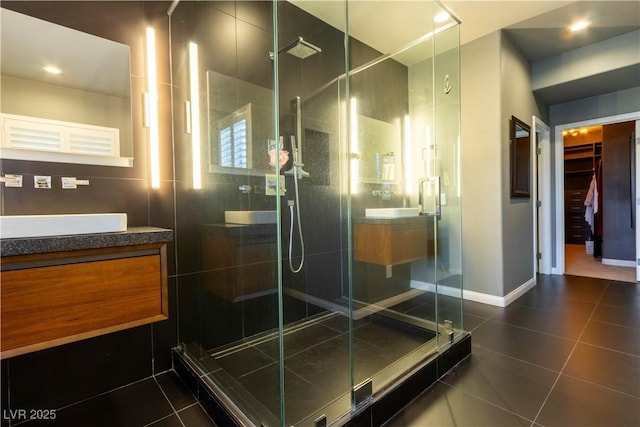 10526 Harvest Wind Dr, Las Vegas, NV 89135 - full bath with tile patterned flooring, vanity, a shower stall, a walk in closet, and baseboards