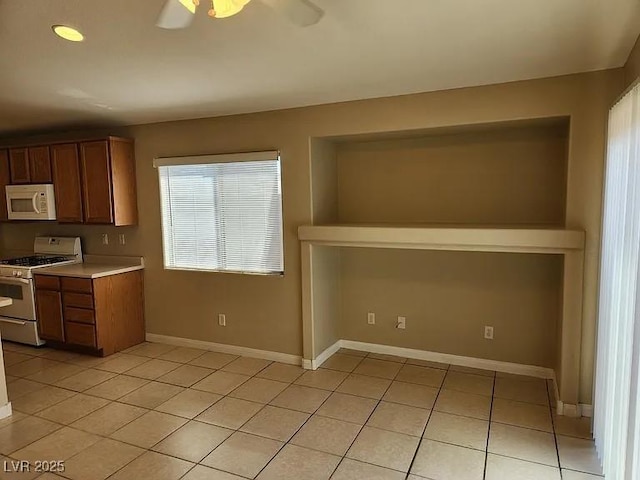 5605 Midnight Breeze St, North Las Vegas, NV 89081 - kitchen with white appliances, light tile patterned floors, ceiling fan, light countertops, and brown cabinets