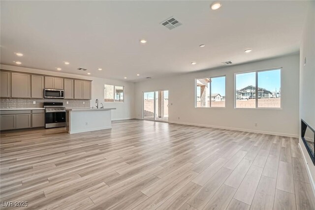 9842 Lost Horse Ave, Las Vegas, NV 89178 - unfurnished living room featuring a sink, light wood-type flooring, recessed lighting, and baseboards