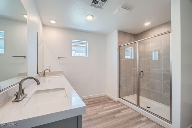 9842 Lost Horse Ave, Las Vegas, NV 89178 - bathroom with double vanity, a stall shower, recessed lighting, wood finished floors, and baseboards